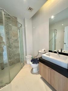 Un baño con lavabo, inodoro y ducha. en Cozy 2 Bedrooms - The Lago Nai Harn by AHP, en Rawai Beach