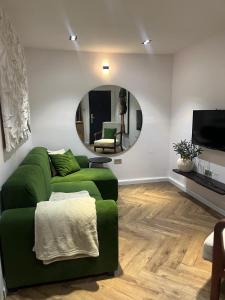 a living room with a green couch and a mirror at Elysia by Joja in Lagos +2 photos