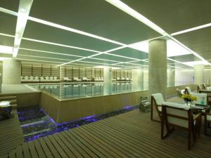 長春市にあるNew Century Grand Changchun Hotelのプールと待合室のあるロビー