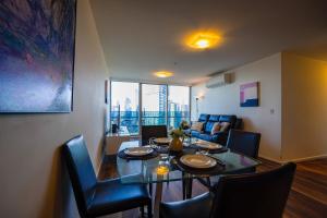 a dining room with a table and chairs and a couch at Southbank 40 in Melbourne