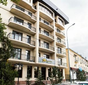 a large apartment building with a sign on it at Hotel FN Shymkent in Shymkent