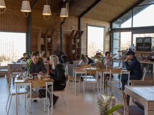 a group of people sitting at tables in a restaurant at Old Mac Daddy in Botrivier