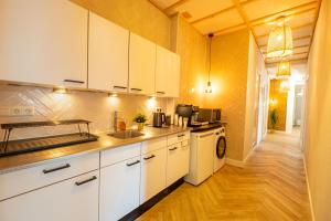 a kitchen with white cabinets and a sink at Hello Stay Utrecht in Utrecht