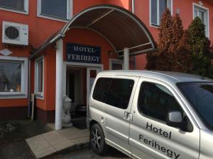 una furgoneta blanca estacionada frente a un edificio en Hotel Ferihegy, en Vecsés