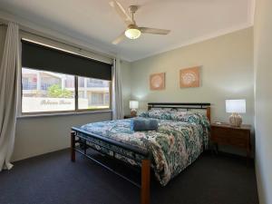 a bedroom with a bed and a large window at Pelican Shore Villa 19 - Kalbarri WA in Kalbarri