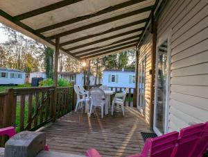 a patio with chairs and a table on a deck at Chez Angel et Flo - E27 - Mobil home tout confort - 15 minute Europa Park - terrasse privée in Boofzheim