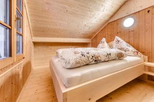 a bedroom with a bed in a wooden cabin at Alp Hütte Bregenzerwald in Schnepfau +20 photos