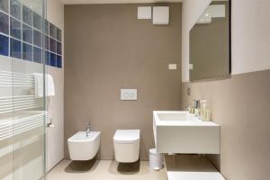 a white bathroom with a sink and a toilet at Verdenoce Agriturismo B&B in Borzano