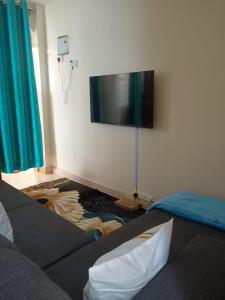 a living room with a flat screen tv on the wall at Bnb kamakis in Ruiru