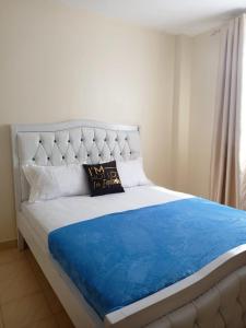 a bedroom with a large bed with a blue blanket at Bnb kamakis in Ruiru