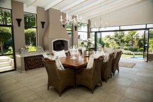 a dining room with a table and chairs and a fireplace at La Vida Luka - Luxury Guesthouse in Pretoria