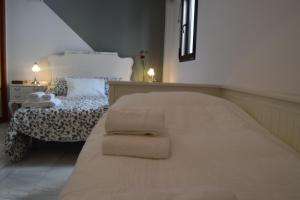 a bedroom with a large bed with towels on it at El Atico Del Gran Capitan in Córdoba