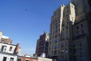 dos edificios altos parados uno al lado del otro en John 3 16 Christian BnB, en Nueva York