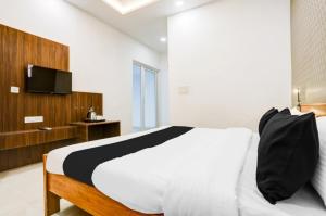 a bedroom with a bed and a tv on a wall at The Grand Blue Hotel in Greater Noida