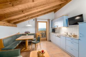 een keuken met een tafel en een eetkamer bij Formsunhof in Siusi +48 foto's