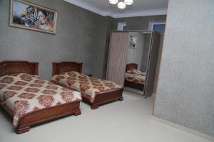 a bedroom with two beds and a mirror at Inn Kavkaz in Makhachkala