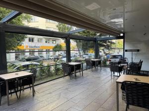 a restaurant with tables and chairs and a view of a street at Sirin Park Hotel in Adana