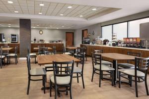a restaurant with wooden tables and chairs and a counter at Wingate by Wyndham Denver Tech Center in Greenwood Village