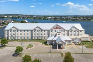 una vista aérea de un gran edificio con un lago en Hilton Garden Inn Granbury, en Granbury