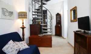 - un salon avec un canapé bleu et un escalier en colimaçon dans l'établissement Casa Trinacria Taormina, à Taormine