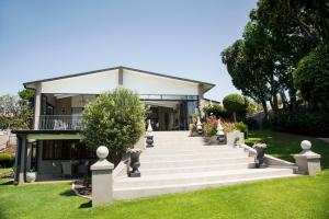 a house with a staircase leading up to a building at La Vida Luka - Luxury Guesthouse in Pretoria