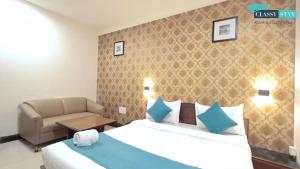a bedroom with a bed and a chair and a couch at Manas Residency Classy Stay in Mumbai