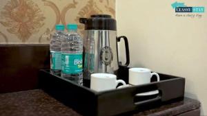 a black tray with bottles of water and cups at Manas Residency Classy Stay in Mumbai