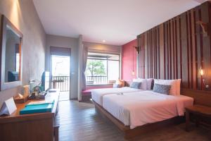 a bedroom with a large bed and a balcony at Ao Prao Resort in Ko Samed
