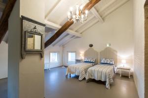 een slaapkamer met 2 bedden en een kroonluchter bij Verdenoce Agriturismo B&B in Borzano