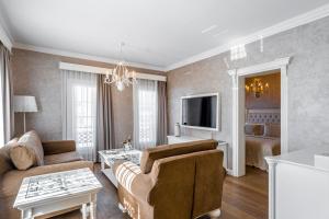 a living room with a couch and a tv at Ena Boutique Hotel & Residences in Bodrum City
