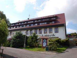 ein großes weißes Gebäude mit rotem Dach in der Unterkunft Penzion Kamzík in Česká Kamenice