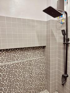 a shower in a bathroom with gray tiles at Casa nel Mezzo - A Pineapple Farm Escapee in Ulot