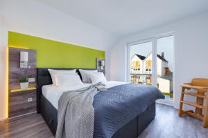 カッペルンにあるFewo Kapitän James Cook Olpenitzの緑の壁と大きなベッドのある寝室
