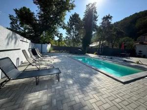 a swimming pool with lounge chairs next to at Vila Amadark in Văliug