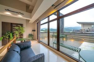 ein Wohnzimmer mit Couch und großem Fenster in der Unterkunft 無門禁24小時進出-遇見礁溪lll免費停車 in Jiaoxi
