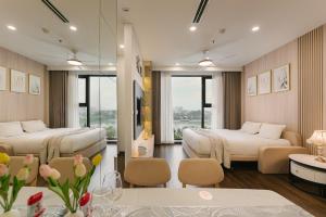a hotel room with two beds and a couch at Rosee House - Masteri West Heights ,Vinhomes Smart City in Nam Tu Liem +140 photos