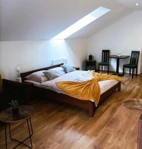 a bedroom with a bed with a yellow blanket on it at Penzión Turzov in Gelnica