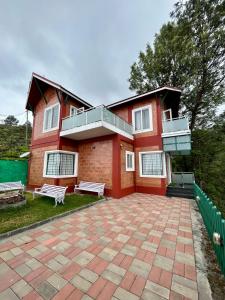 a red house with a patio in front of it at S ELLA Residency in Kotagiri