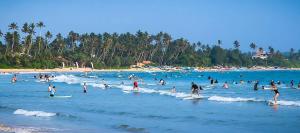 a group of people on surfboards in the water at a beach at YOUTHENI VILLA in Weligama