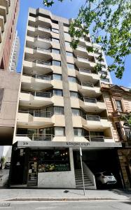 a tall building with a store in front of it at Kingsleigh Apartments Sydney in Sydney
