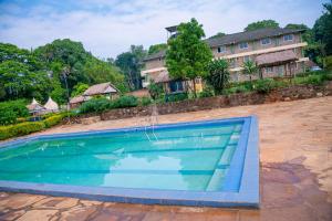 a swimming pool in front of a house at Malava-K-Resort in Kakamega