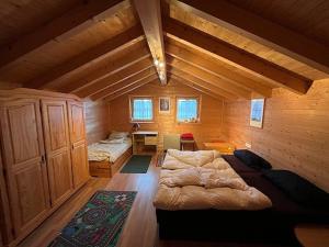 a bedroom with a large bed in a wooden room at Ferienhaus Biberweg im Feriendorf Reichenbach 09 in Nesselwang +8 photos