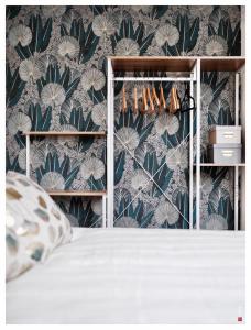 1 dormitorio con papel pintado verde y blanco y 1 cama en Magnifique 3 étoiles 10 min de Disney et 40 min de Paris, en Bailly-Romainvilliers