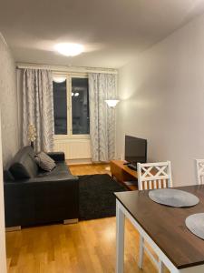 a living room with a black couch and a table at Vaasa Apartments 4 in Vaasa