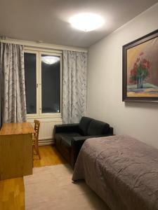 a bedroom with a bed and a couch and a table at Vaasa Apartments 4 in Vaasa