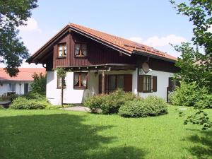 a house with a green yard in front of it at Ferienhaus Biberweg im Feriendorf Reichenbach 03 in Nesselwang