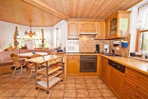 a kitchen with a table and a dining room at Ferienhaus Biberweg im Feriendorf Reichenbach 03 in Nesselwang +14 photos