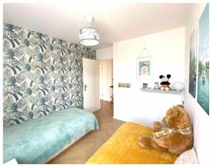 un dormitorio con un osito de peluche sentado en un sofá en Magnifique 3 étoiles 10 min de Disney et 40 min de Paris, en Bailly-Romainvilliers 29 fotos más