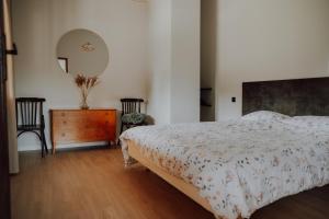 a bedroom with a bed and a dresser and a mirror at Grava Cottage in Tukums