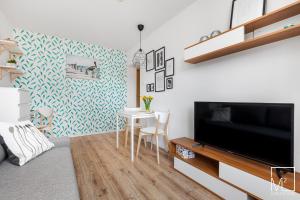 een woonkamer met een televisie en een tafel en stoelen bij Super Studio Oldtown in Gdańsk +3 foto's